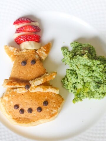 Cat in the hat pancake with green eggs on white plate