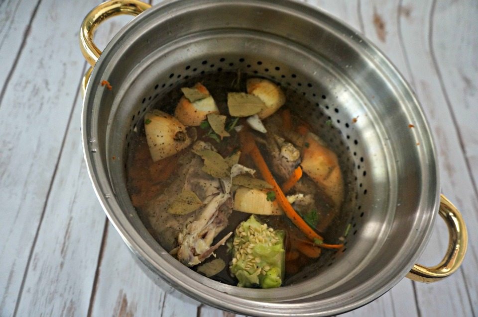 Vegetable scraps and chicken bones in large stock pan