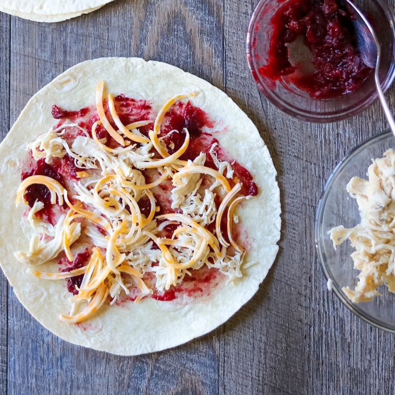 leftover turkey and cranberry sauce on a tortilla topped with cheddar cheese
