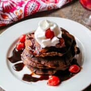 Chocolate Pancakes on White Plate topped with whipped cream