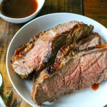 Sliced New York Strip Roast on white platter