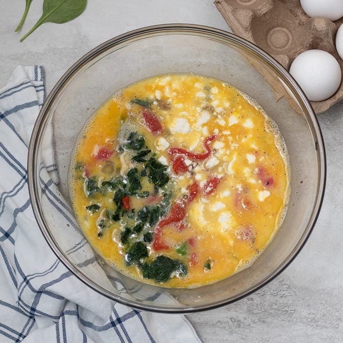 Eggs mixed with spinach and roasted red peppers