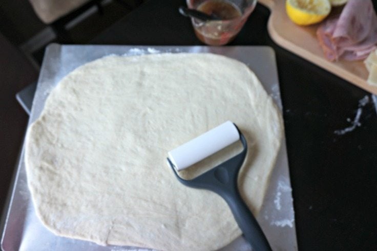bread dough rolled out on baking sheet.