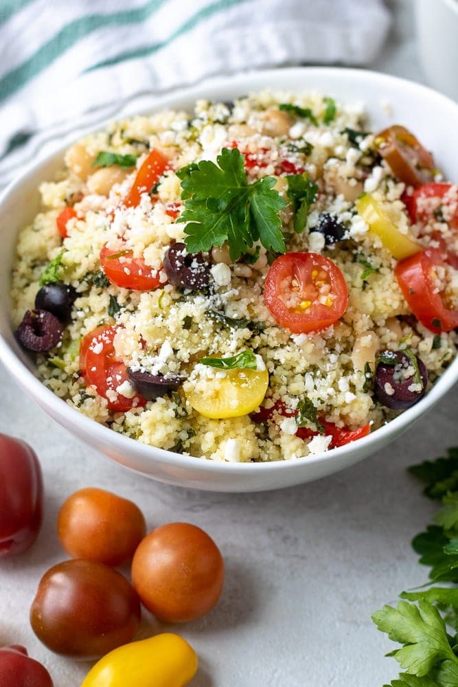 Couscous Salad with tomatoes and olives in white serving bowl