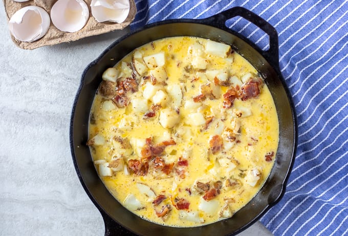 Egg Custard over Potatoes and Bacon in cast iron skillet.