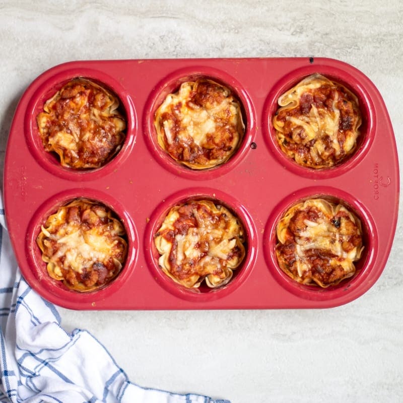 Baked Lasagna Cupcakes in red muffin tin