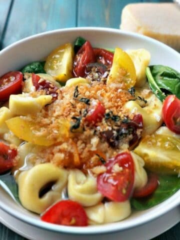 Tortellini in rich broth with spinach and tomatoes