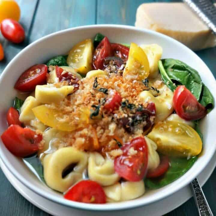 Tortellini in rich broth with spinach and tomatoes