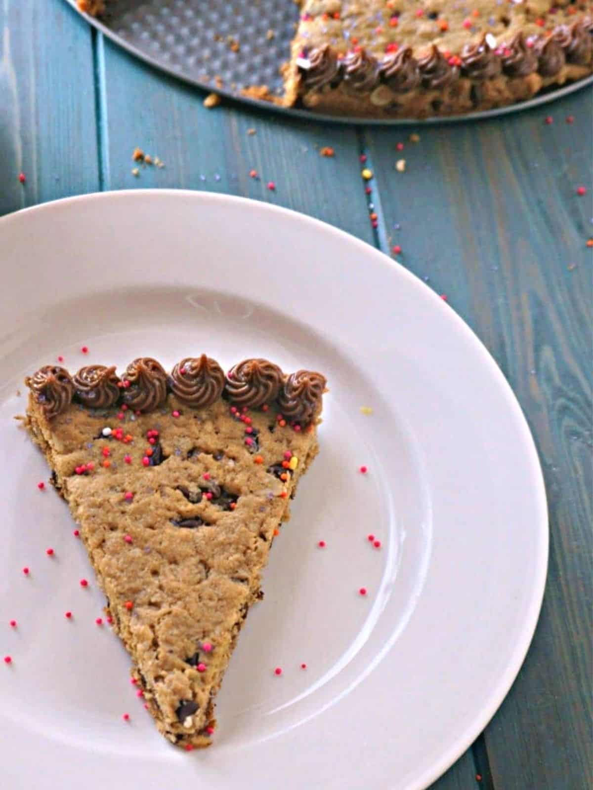 Slice of gluten-free cookie cake on white plate. 