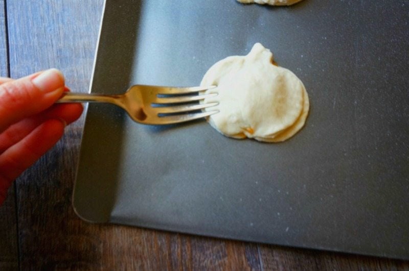 Using a fork to crimp together pumpkin pie cookies