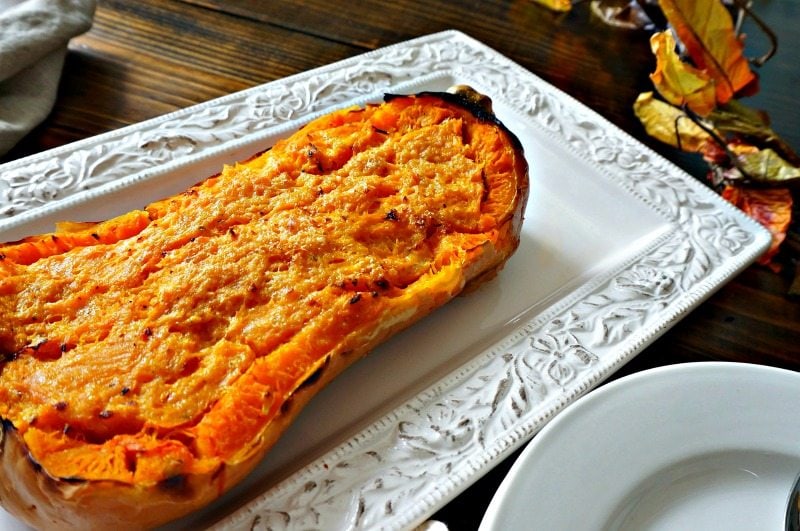 Butternut Squash baked with Parmesan Cheese on white platter.