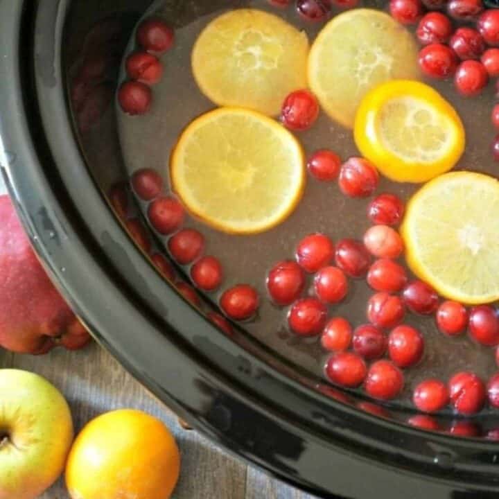 Orange Pineapple Spiced Cider in slow cooker with oranges and cranberries