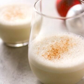 2 glasses of Vegan Eggnog topped with grated nutmeg