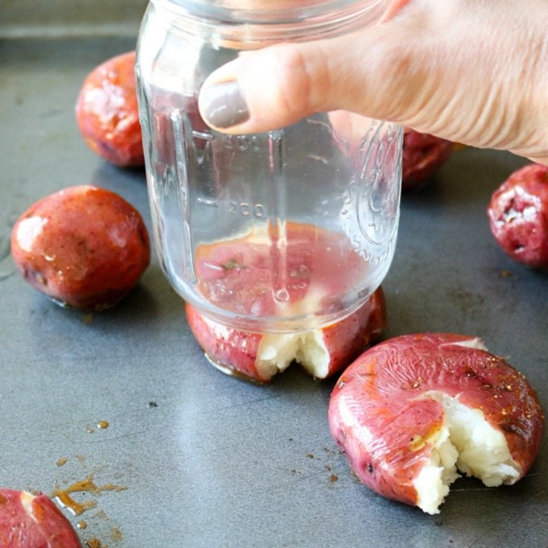 Smashing red potatoes with glass jar