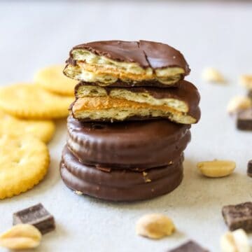 Tagalong Cookies broke open to show butter cracker, peanut butter, and chocolate layer