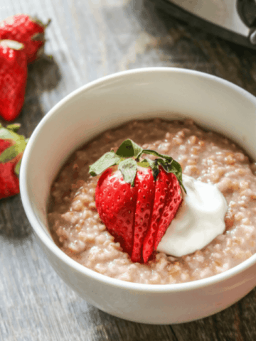 Bowl of oatmeal topped with strawberries and yogurt