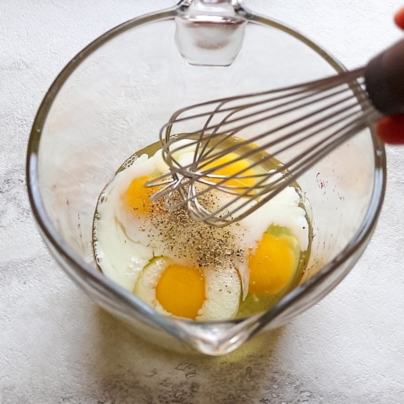 Mixing up eggs for ham and egg cups in glass measuring cup