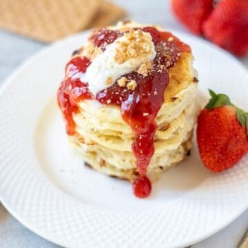 Stack of Strawberry Pancakes with fresh strawberry sauce on white plate