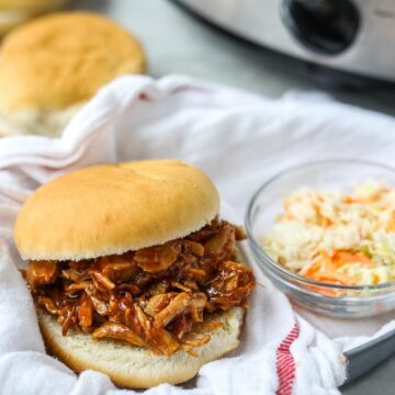 Pulled Pork Sandwich with coleslaw in basket next to slow cooker