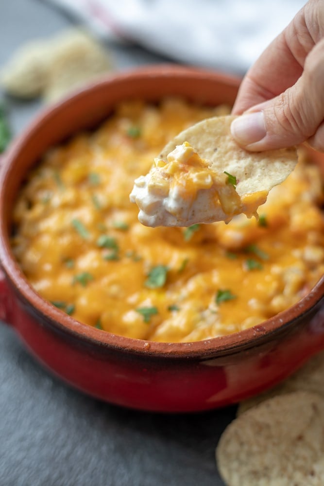 Chip scooping out Hot Mexican Corn Dip