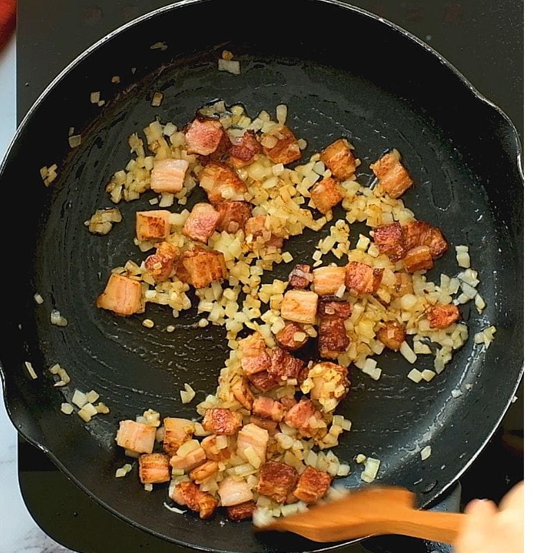 Bacon and Onion being sauteed in cast iron skillet