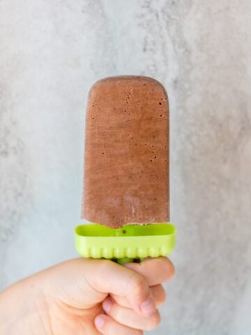Child's hand holding a homemade fudgesicle