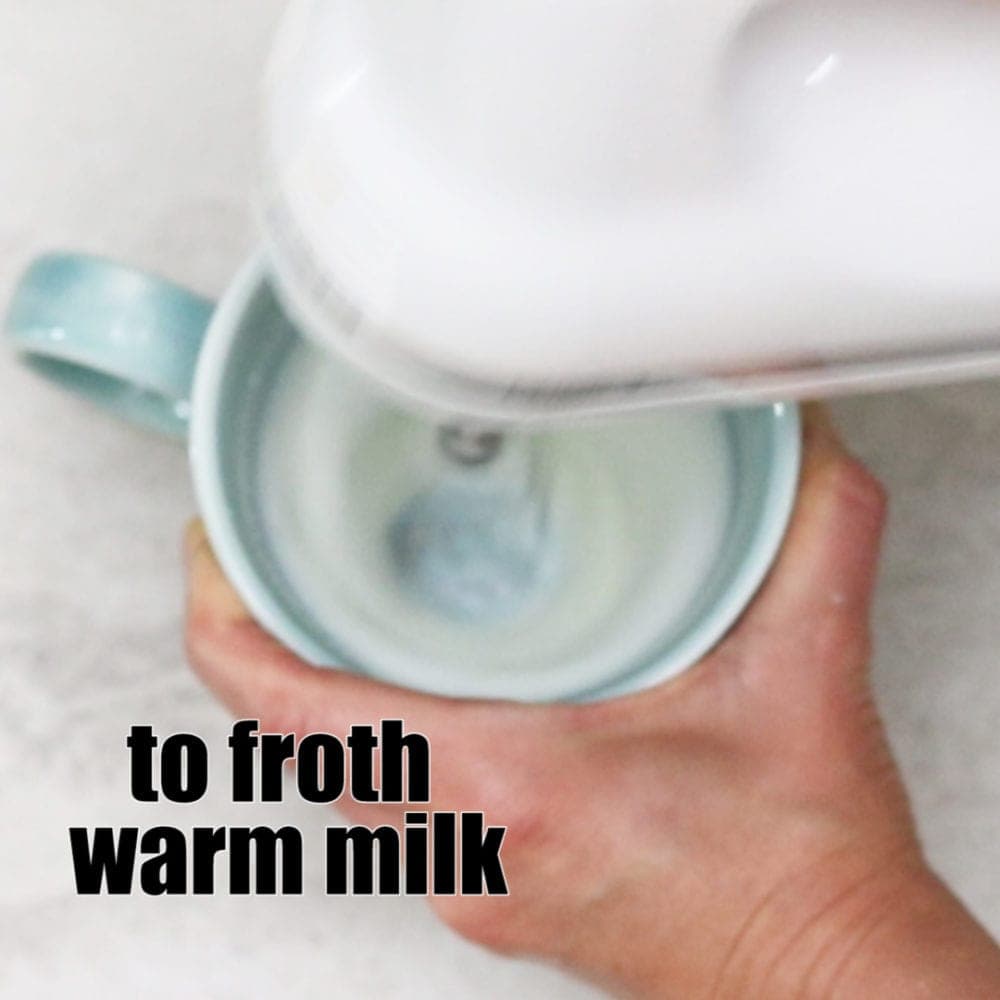 Kitchen Mixer Frothing Milk in blue mug with text that reads to froth warm milk.