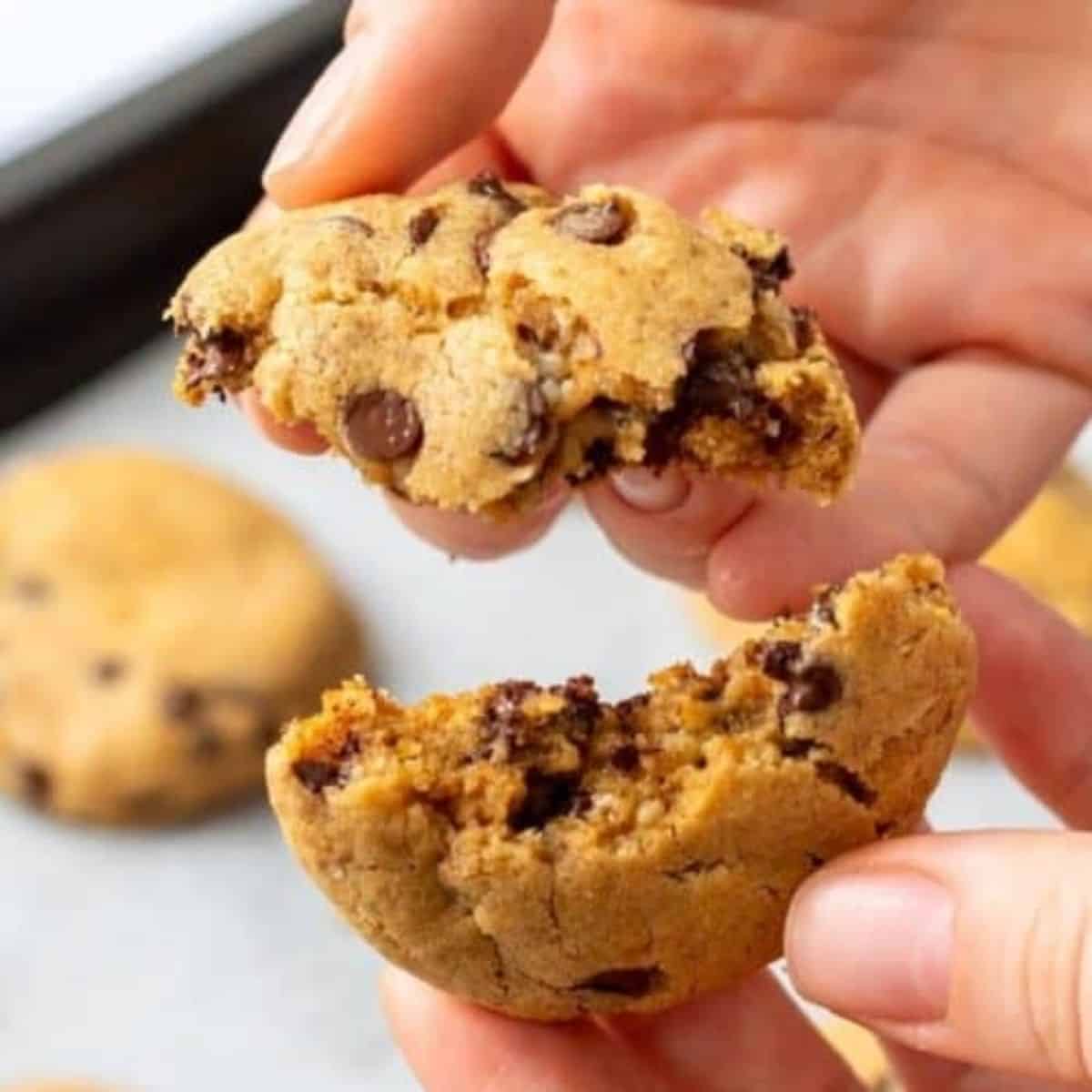 Cookie being broken open to show filled with chocolate.