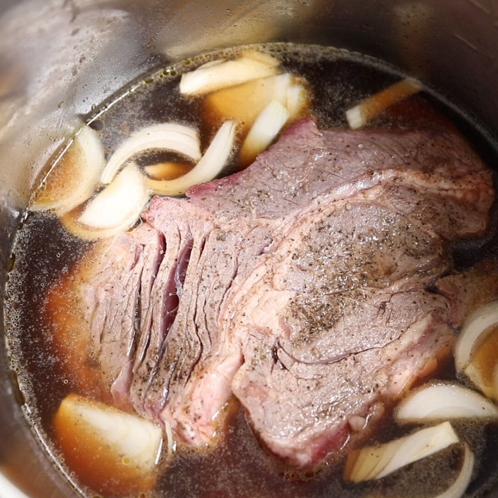 Instant Pot filled with ingredients for easyfrench dip sandwiches