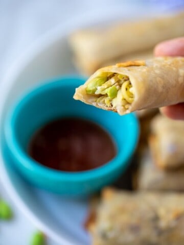 Vegetable Eggroll being dipped into sweet and sour sauce