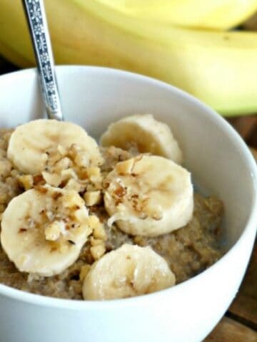 bowl of quinoa porridge topped with bananas and nuts