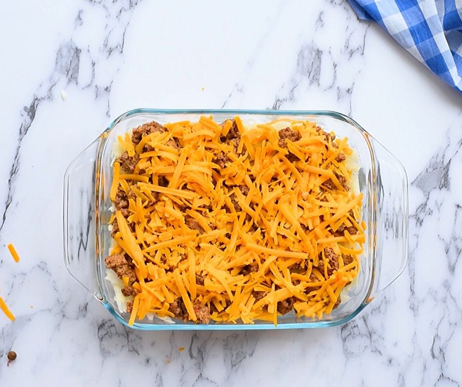 turkey sausage and shredded cheese overtop shredded hashbrown potatoes