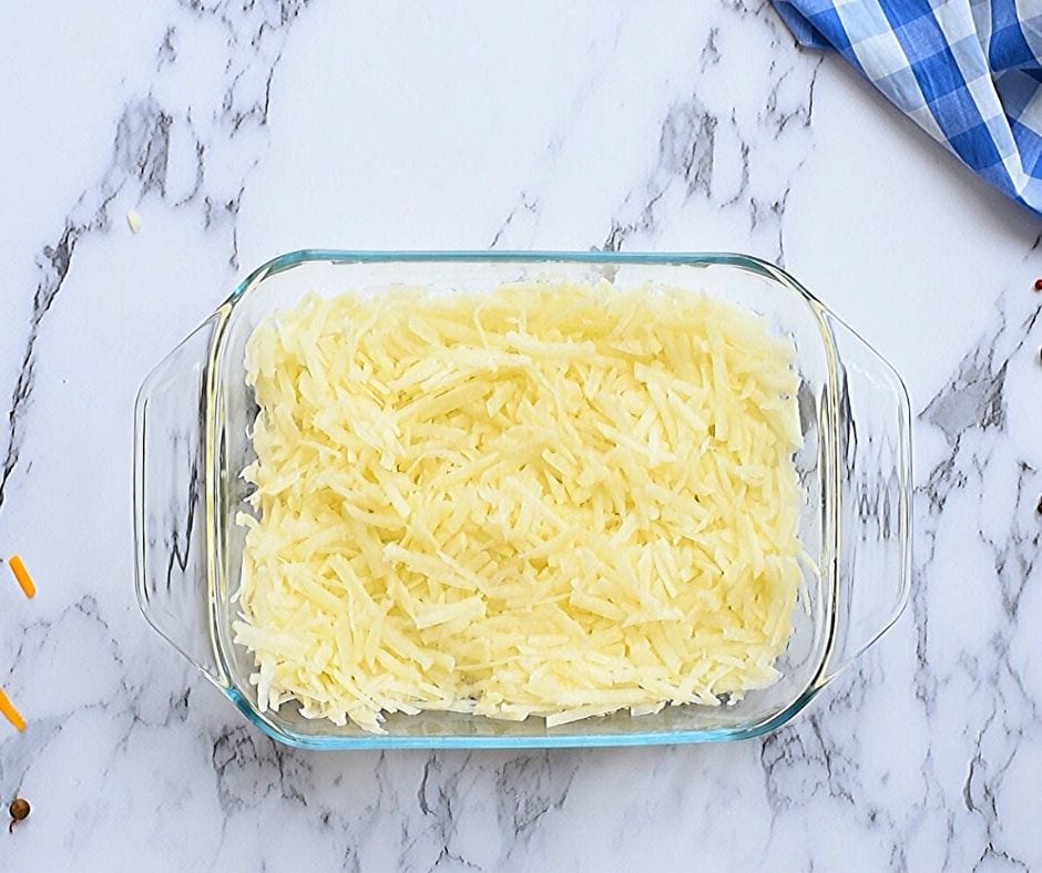baking dish with hash browns spread out in layer