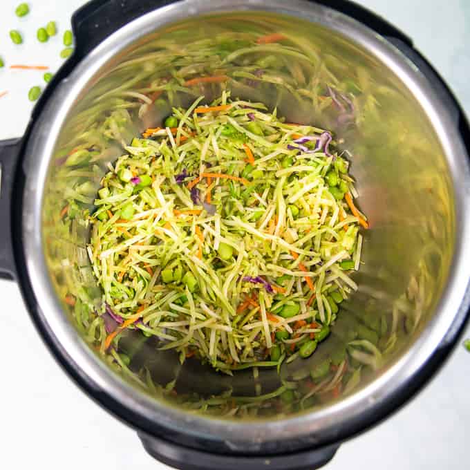Shredded broccoli and carrots in inner pot of instnat pot. 