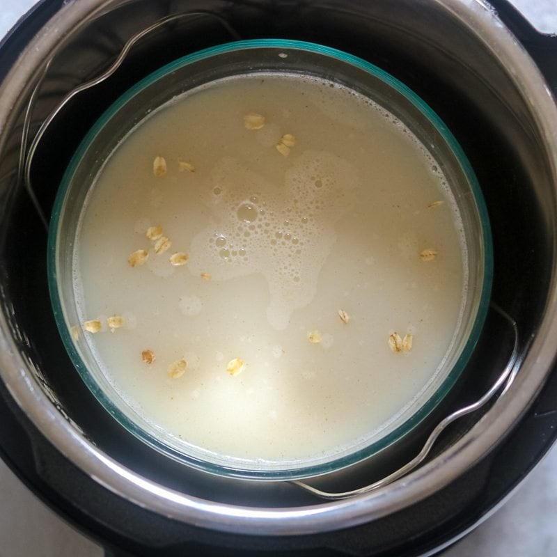 glass bowl filled with milk, water and oats sitting on rack in instant pot
