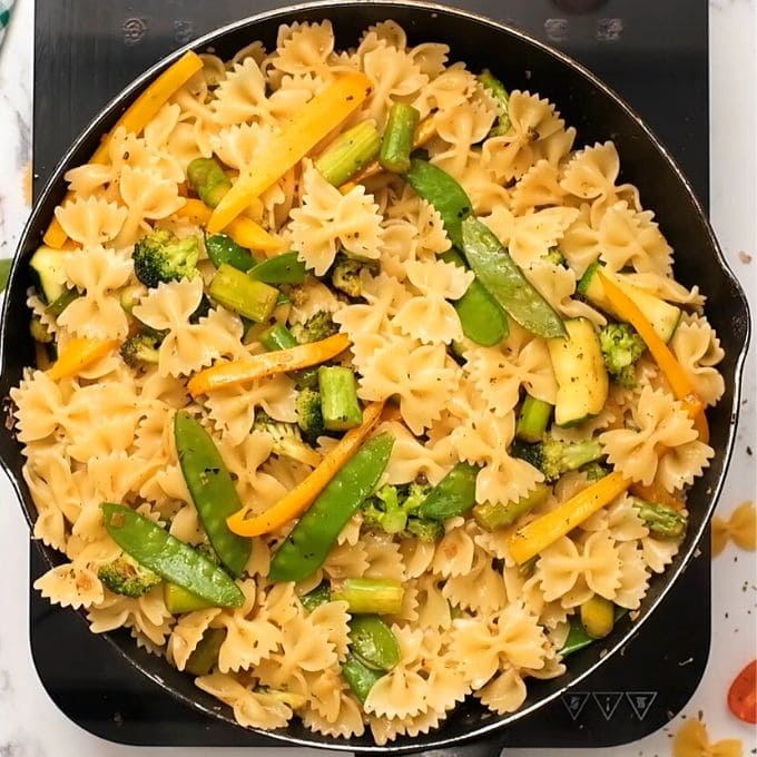 Pasta with sauteed vegetables  in skillet.