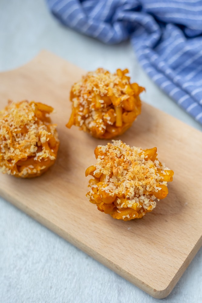 Mac and Cheese Muffins on wooden cutting board.