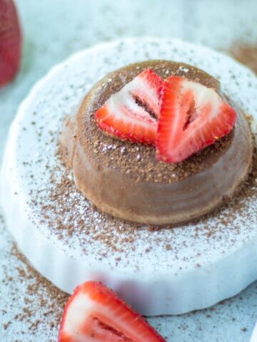 Chocolate Panna Cotta on white platter with strawberries
