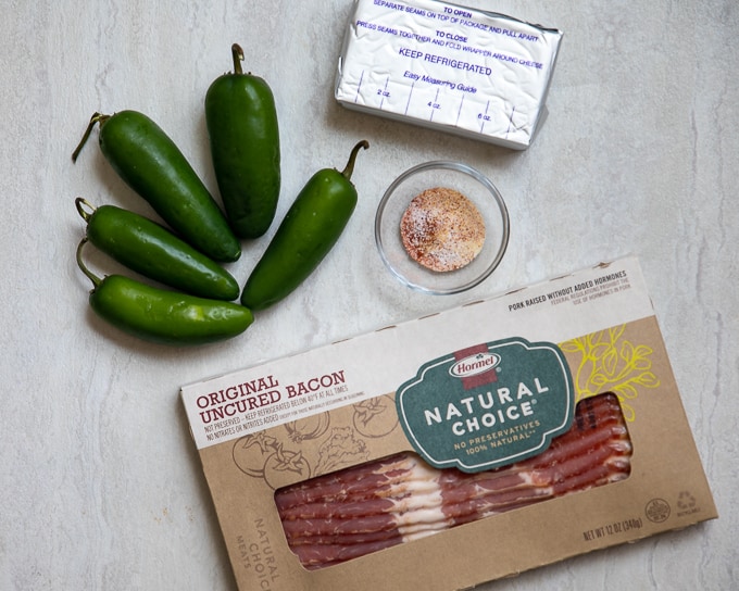Ingredients for Jalapeno Poppers on counter. Jalapenos, cream cheese, bacon and spices