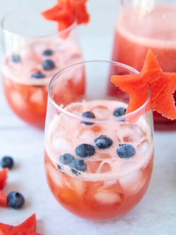 2 glasses of watermelon sangrias with blueberries and watermelon stars