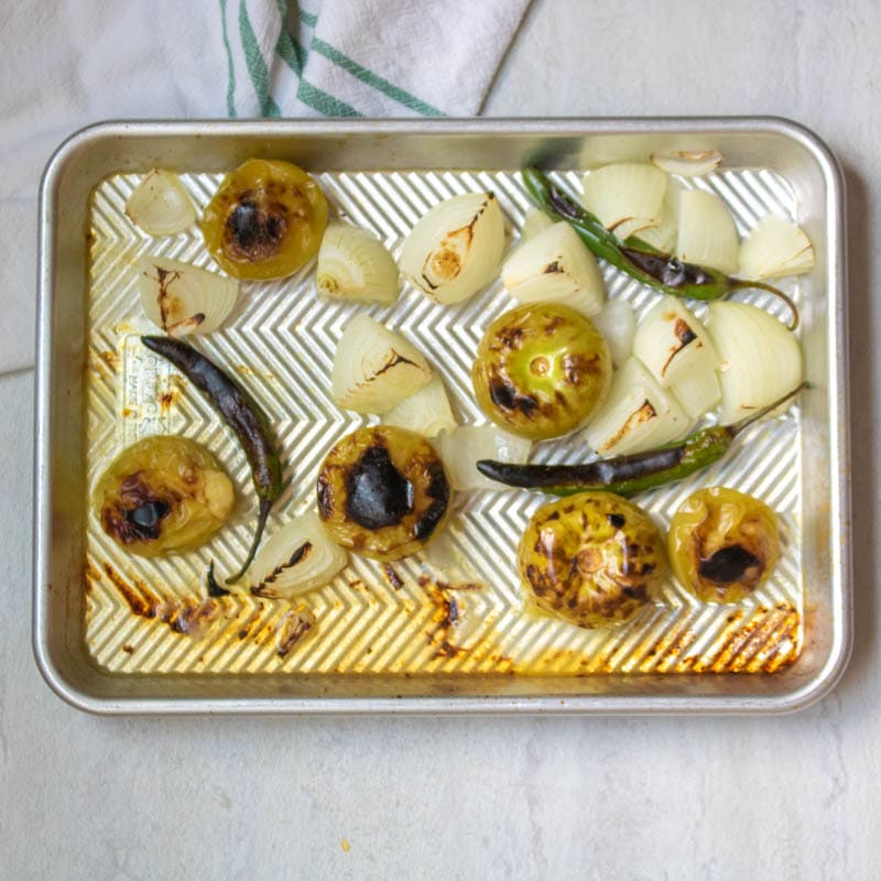 Broiled Tomatillos and onions on Baking Sheet.