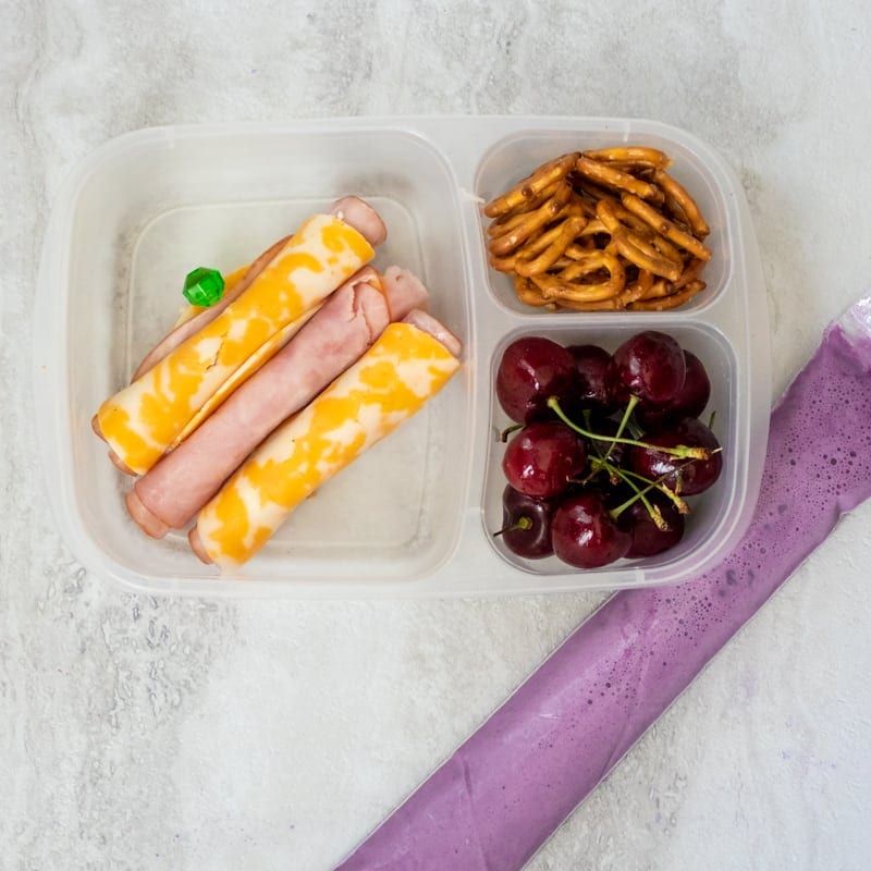 Ham and Cheese Roll Ups in lunch box with cherries, and yogurt