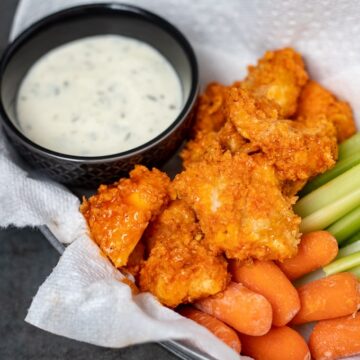 Boneless wings with ranch dressing and celery in basket