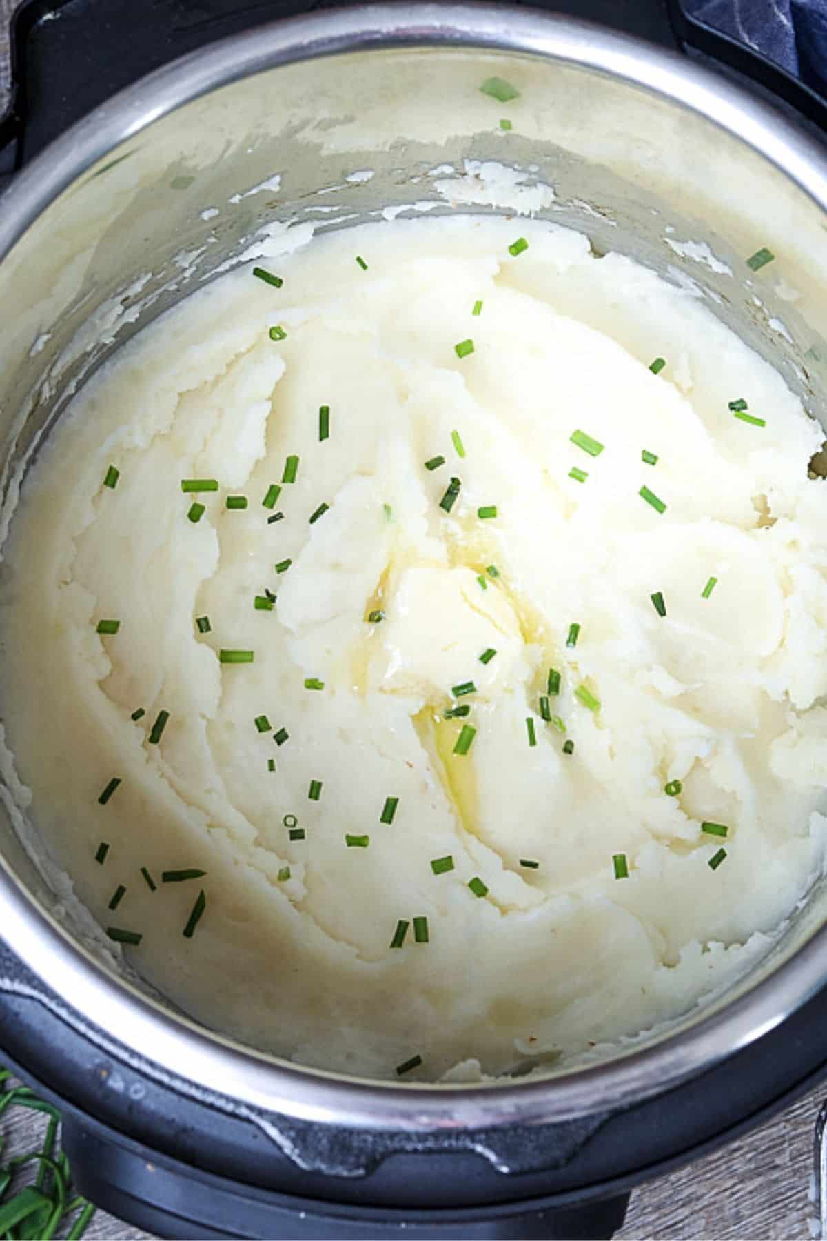 Bowl of Creamy Mashed Potatoes next to Pressure Cooker