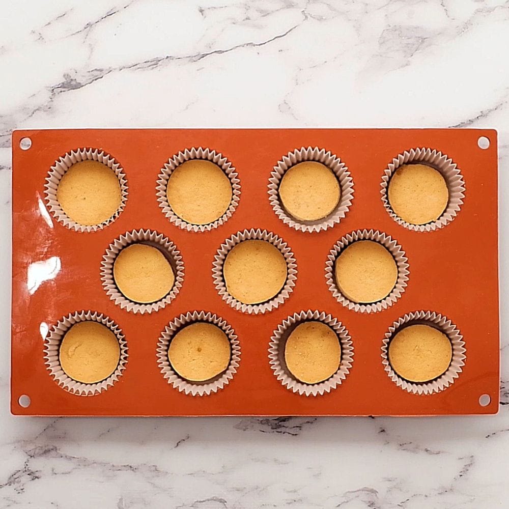 A mini muffin tin liner with liners and vanilla wafers.