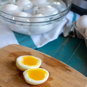 a soft boiled egg cut open on wooden cutting board