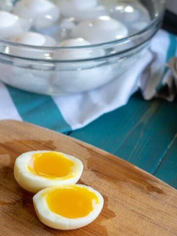 a soft boiled egg cut open on wooden cutting board