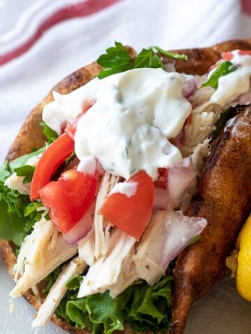 Pita bread stuffed with shredded chicken and diced tomatoes and Tzatziki