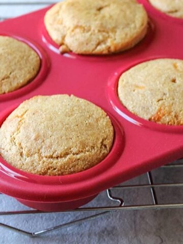 Red muffin tin with corn bread muffins