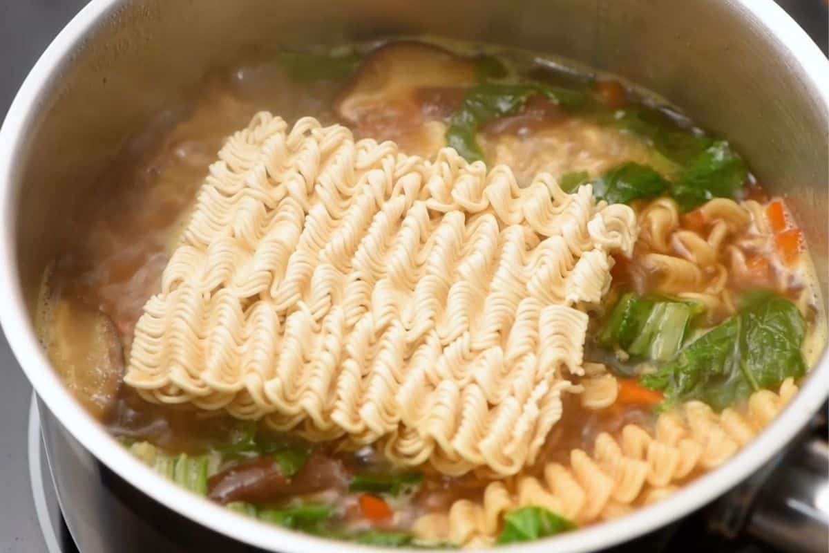 Ramen noodles cooking in broth. 